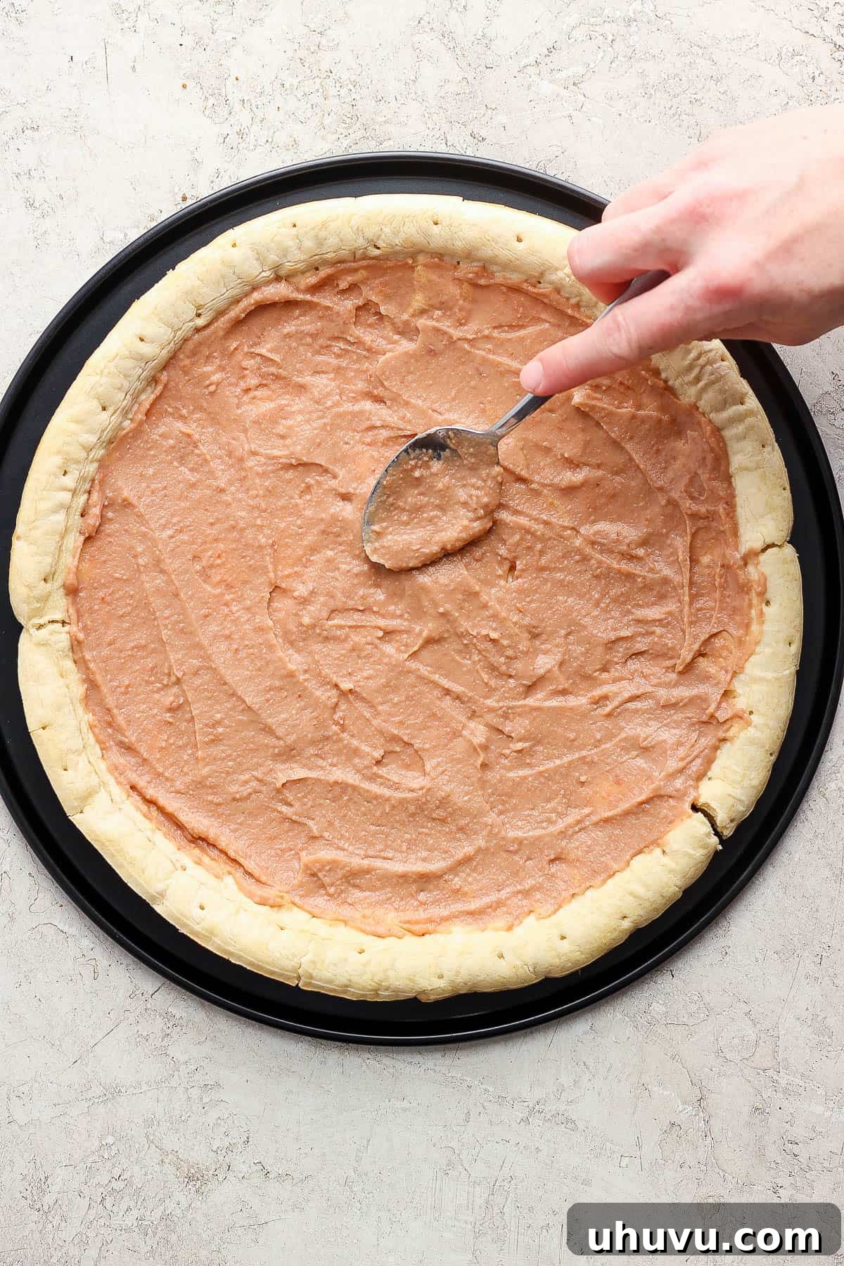 Zesty Mexican Pizza 6 Refried beans spread on a pizza crust.