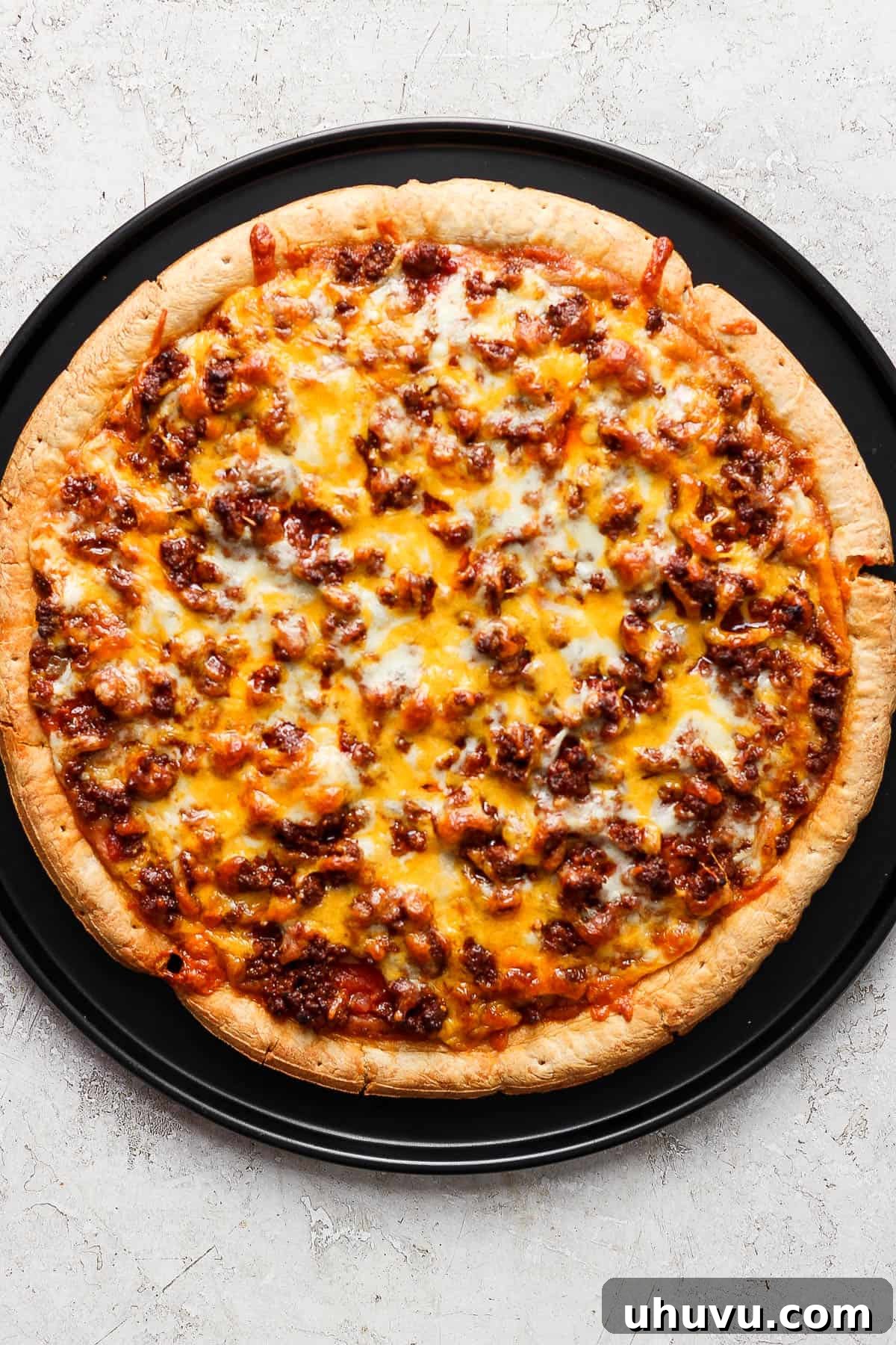 Zesty Mexican Pizza 9 A freshly baked homemade taco pizza, hot out of the oven, with perfectly melted cheese, seasoned taco meat, salsa, and refried beans forming a vibrant and inviting base.
