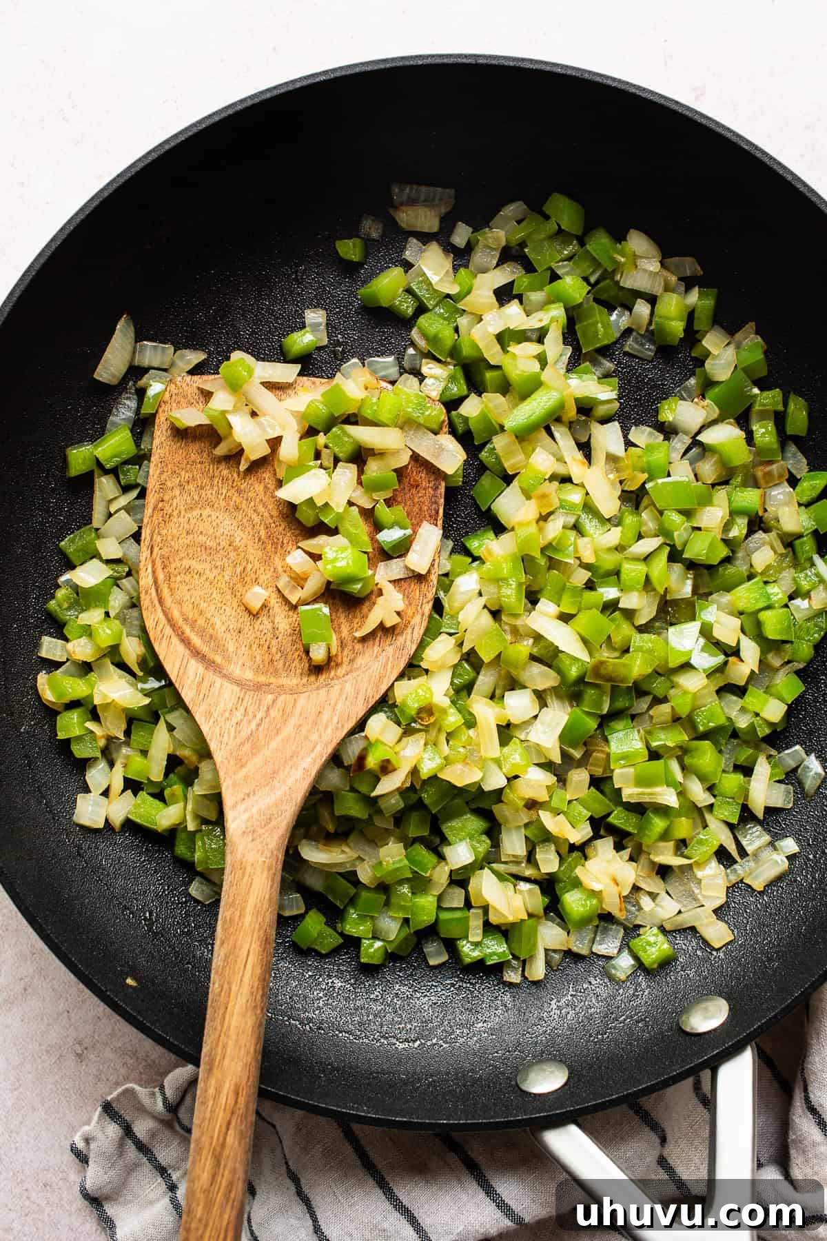 Fiesta Black Bean Melts 4 Bell peppers and onions cooking in a skillet with olive oil.