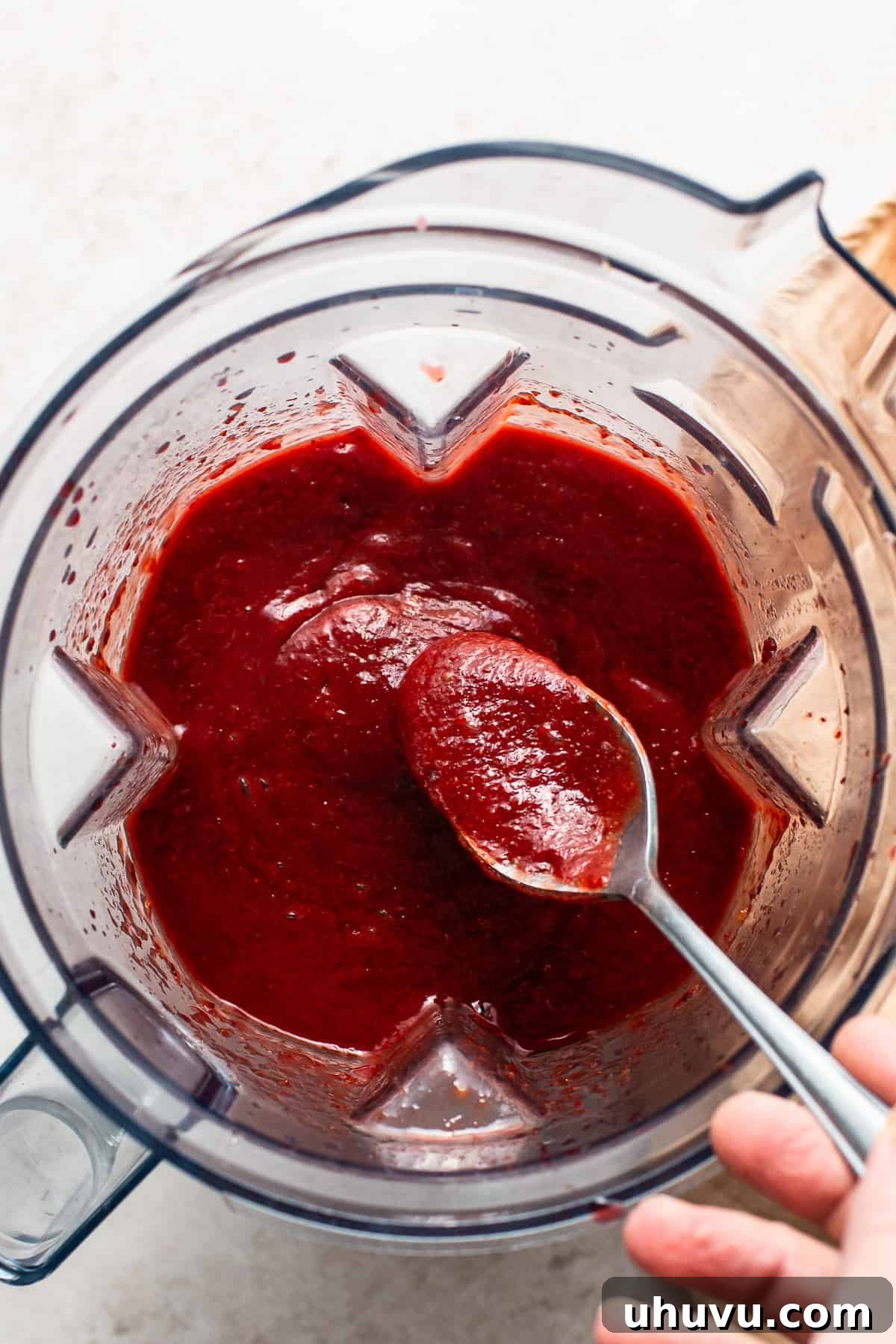 Homemade Chamoy Perfection 6 A spoon being dipped into smooth, rich homemade chamoy sauce in a blender, illustrating the perfect consistency after blending.