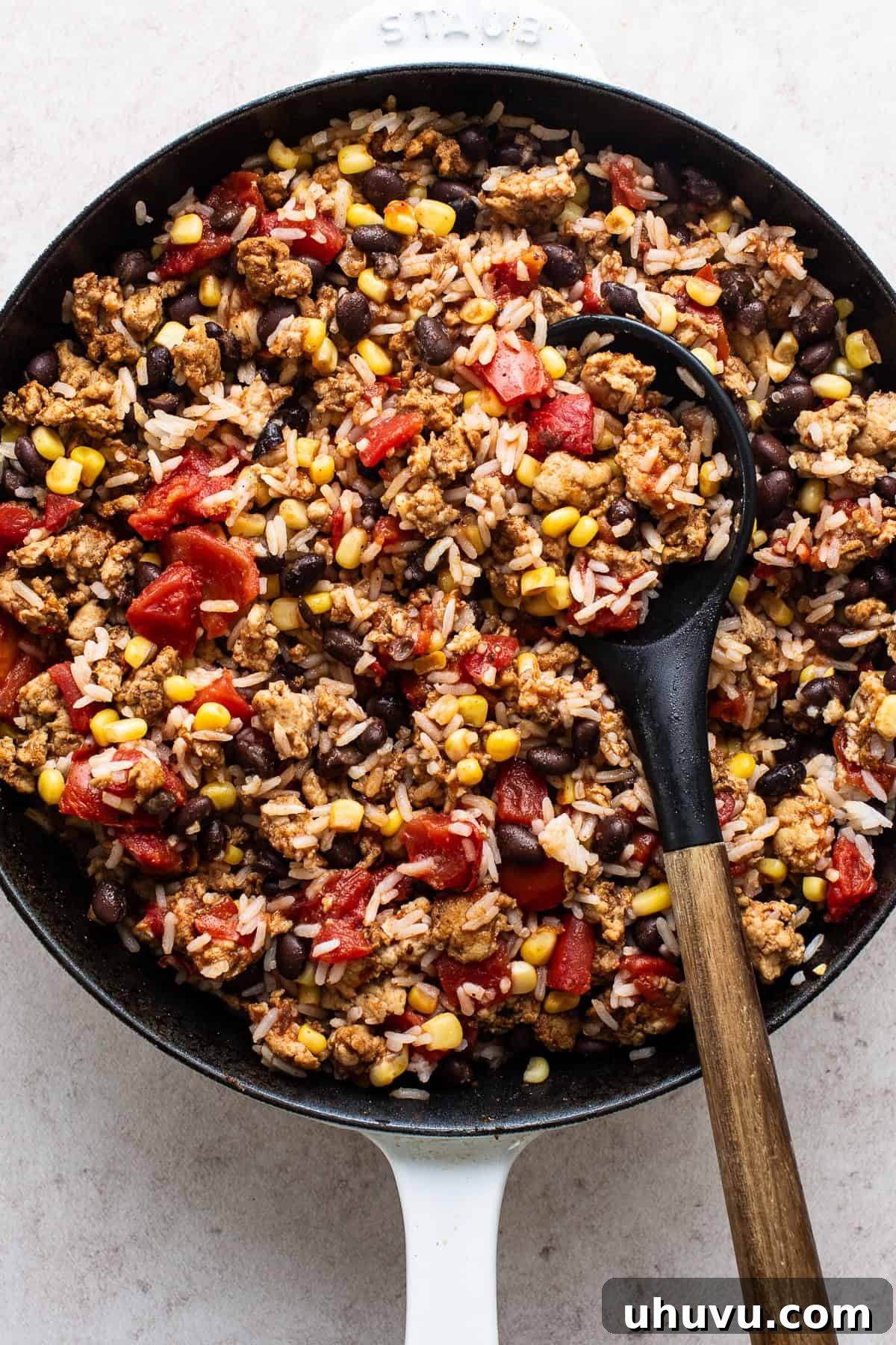 Fiesta Stuffed Peppers 4 A skillet filled with the cooked Mexican stuffed pepper filling, featuring ground turkey, fire-roasted tomatoes, rice, black beans, and corn.
