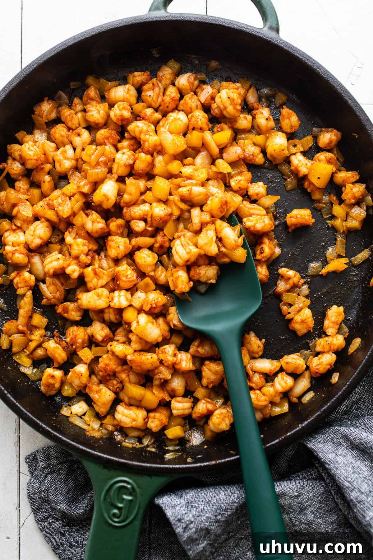Zesty Shrimp Queso Melts 5 A cast-iron skillet filled with perfectly cooked pink shrimp, tender onions, and colorful bell peppers, sizzling slightly.