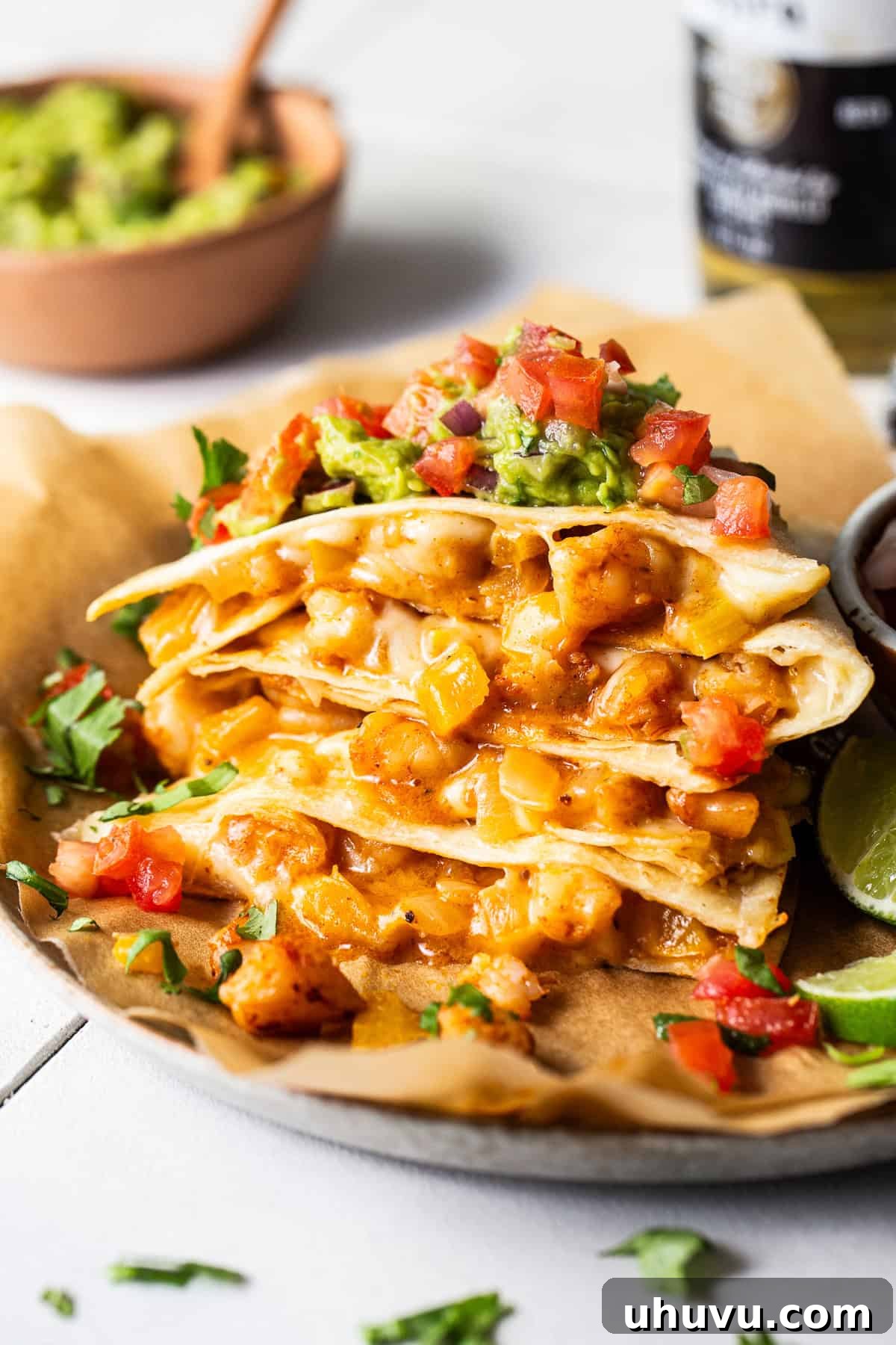 Zesty Shrimp Queso Melts 8 A stack of golden-brown shrimp quesadillas, cut into wedges, artfully arranged on a serving plate.