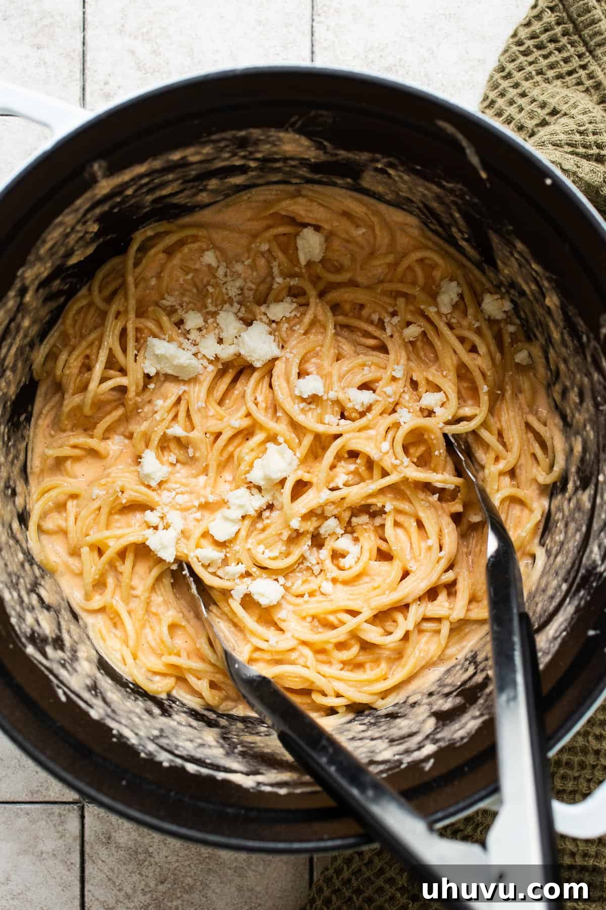 Crimson Spaghetti 7 Spaghetti being tossed with the creamy red sauce in a large pot, ensuring even coating.