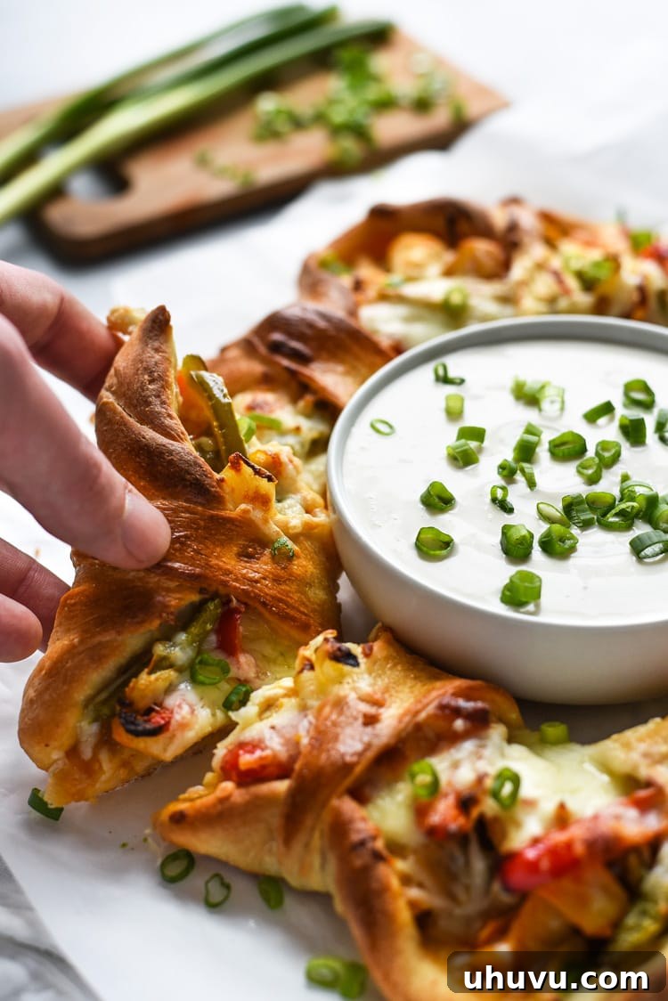 Buffalo Fajita Pizza Wreath 5 The Buffalo Chicken Fajita Pizza Ring, freshly baked and garnished with green onions and a dipping sauce bowl in the center.