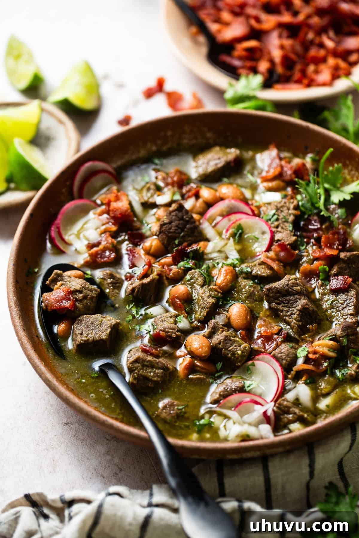 Rich Beef Broth 8 Carne en su Jugo served in bowls and garnished with cilantro, onion, and radishes.
