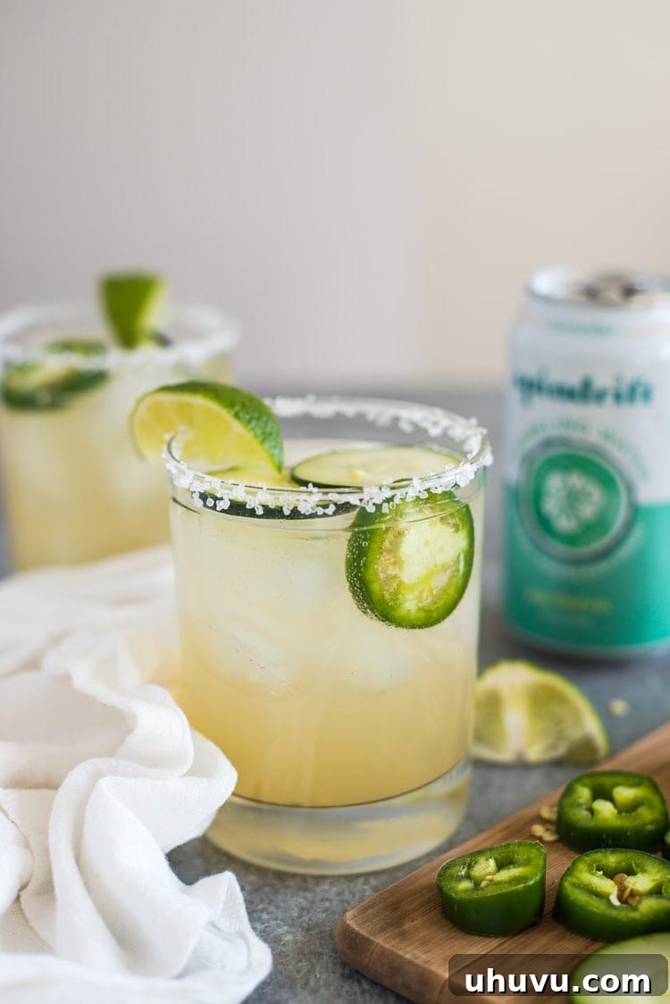 Cool Heat Margarita 5 A Cucumber Jalapeño Margarita, viewed from above, with fresh cucumber slices and jalapeño floating, highlighting the refreshing nature of the drink.
