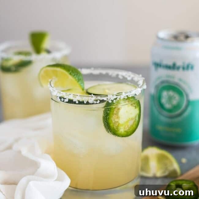 A Cucumber Jalapeño Margarita made with refreshing cucumber sparkling water, fresh jalapeños and organic agave nectar. Garnished with cucumber slices and jalapeño rounds.
