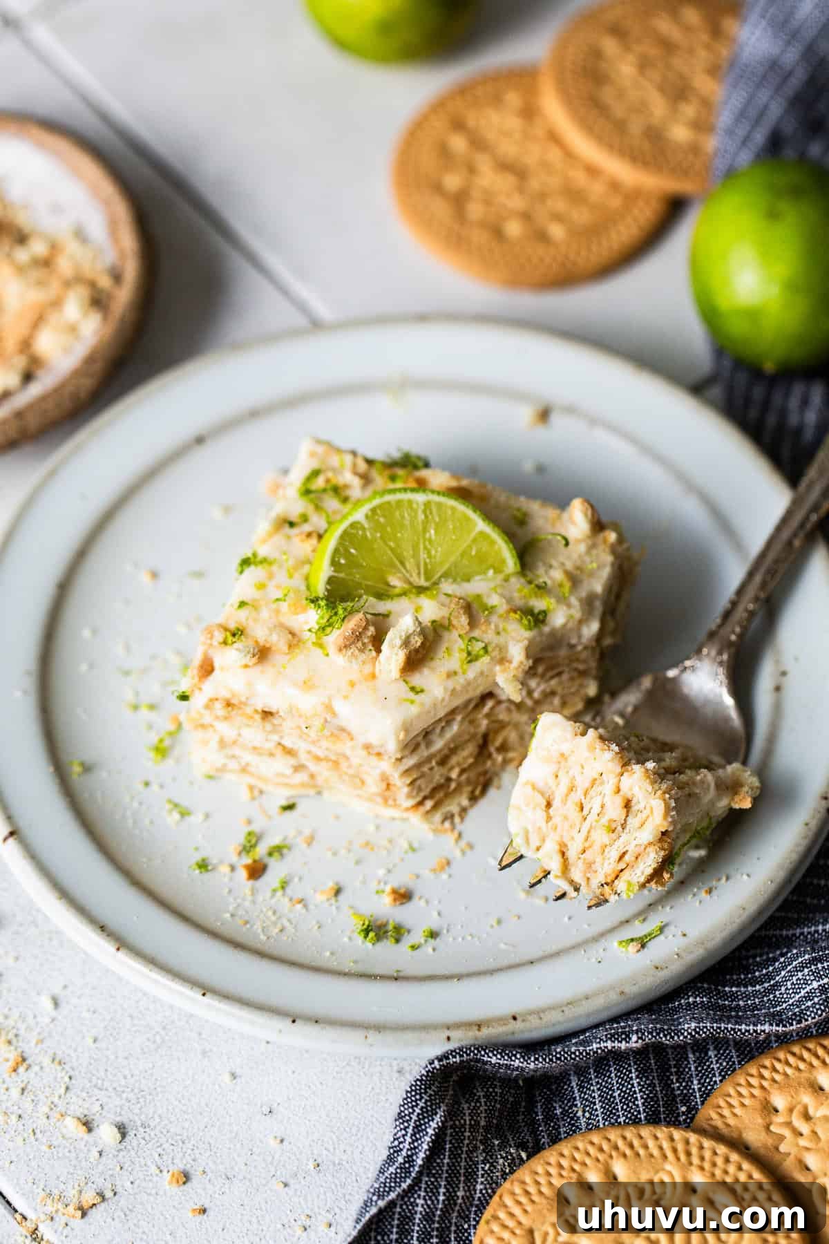 Carlota de Limón served on a plate with lime zest and crushed cookies as toppings.