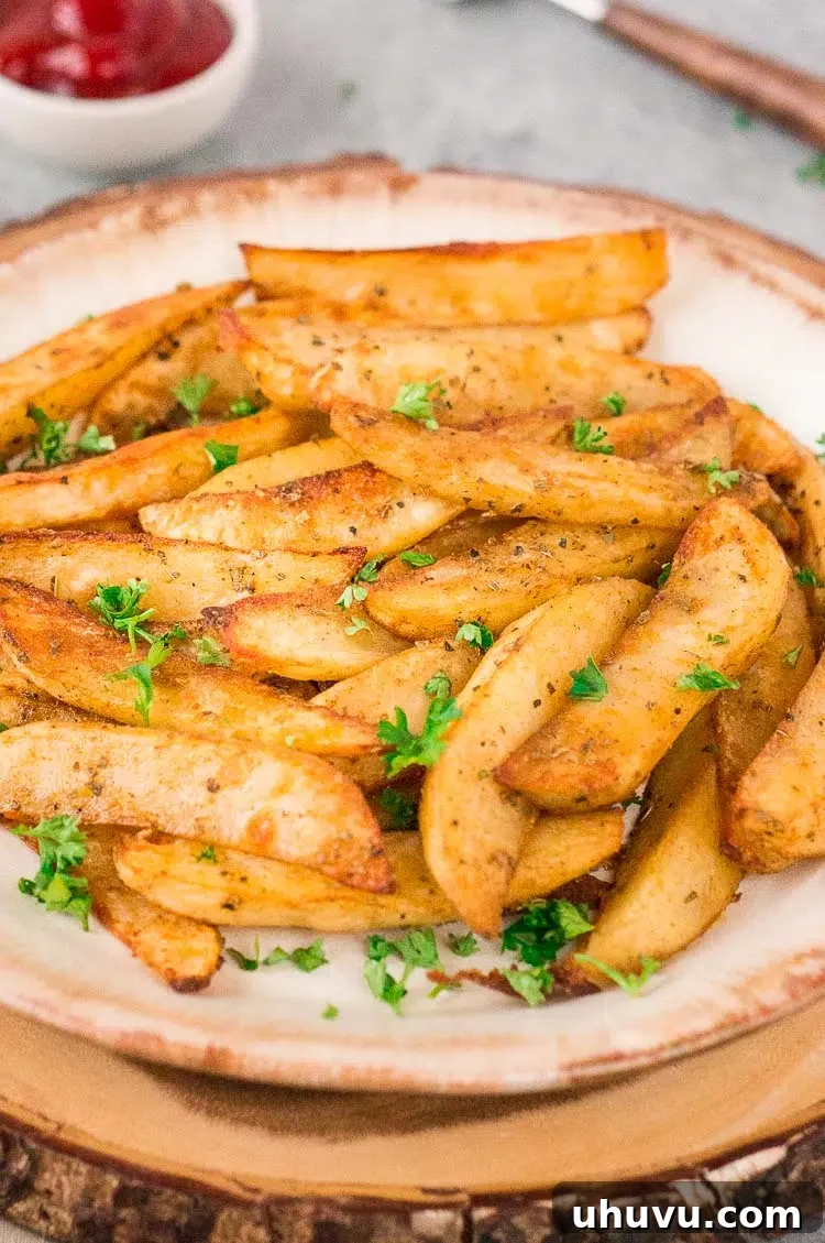 Close up of a plate of baked potato wedges, perfectly golden and crispy