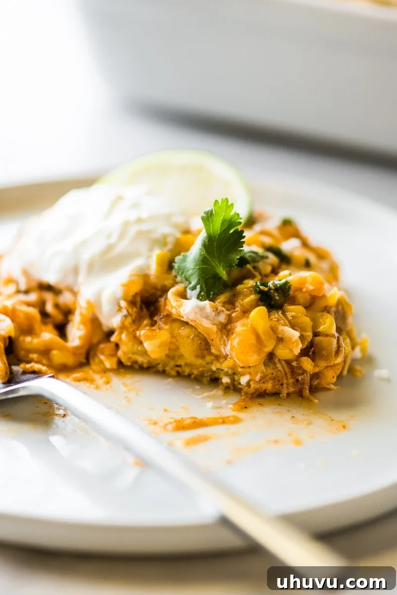 Southwest Chicken Tamale Bake 5 A serving of Chicken Tamale Casserole on a white plate with a fork.
