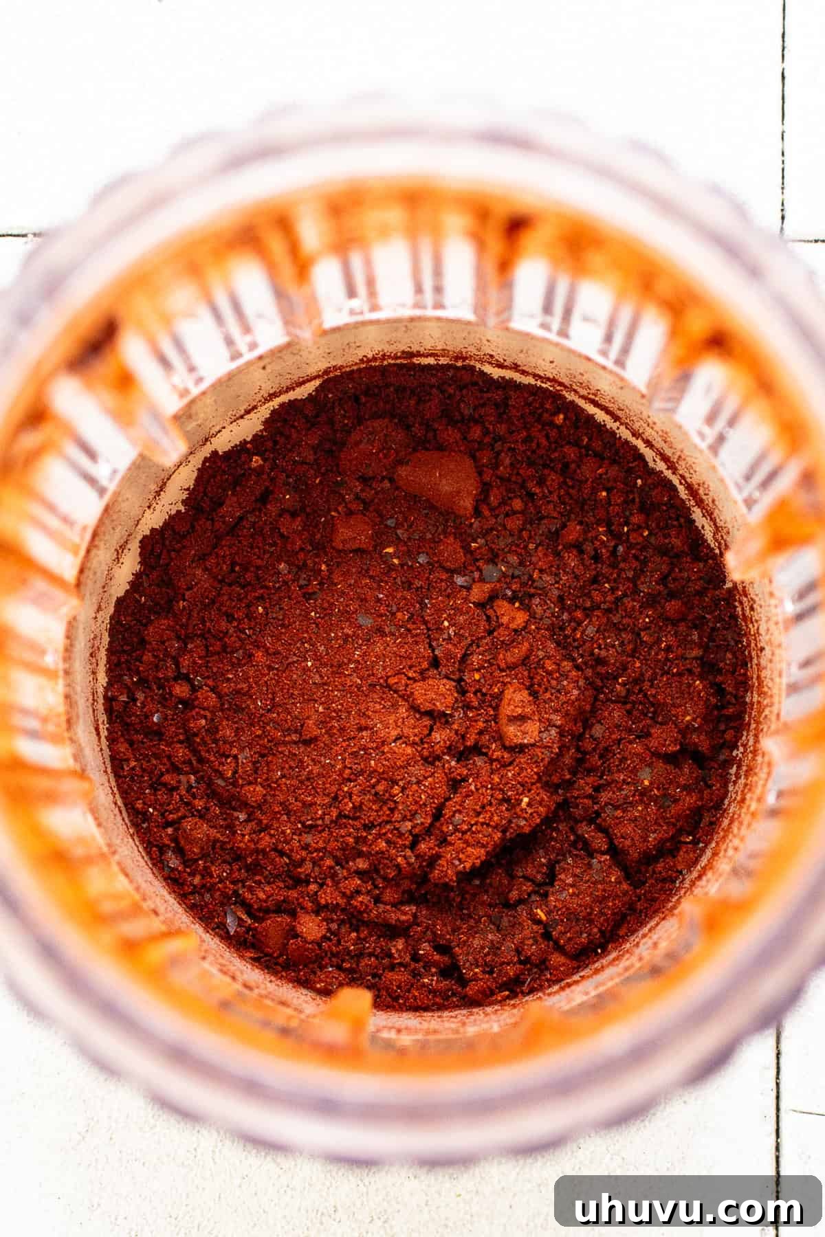 Your Signature Chili Powder Blend 5 Toasted guajillo chiles being ground into a fine powder in a blender or spice grinder.