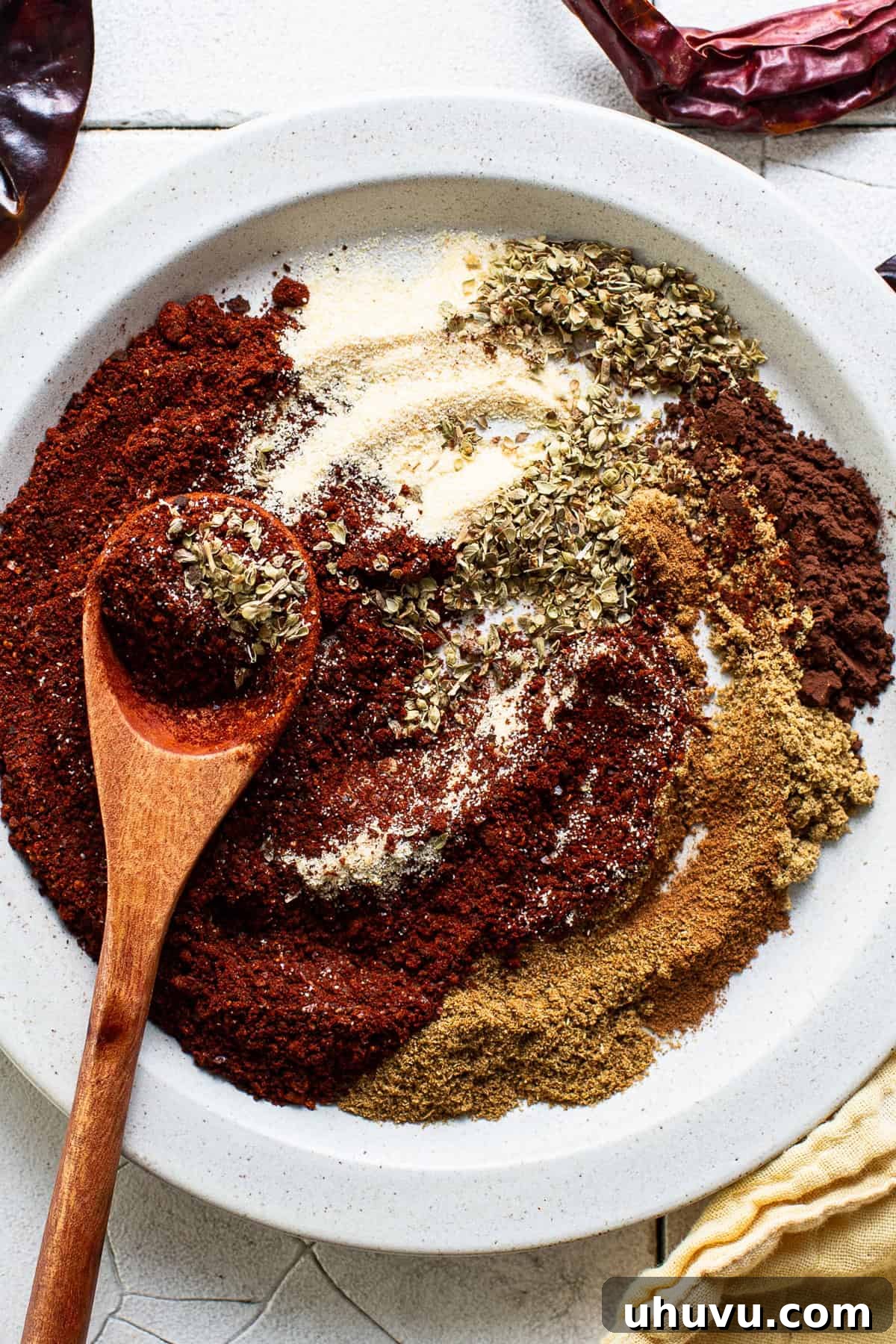 Your Signature Chili Powder Blend 6 Ground chili powder and other individual spices gathered in a bowl, ready to be mixed together.