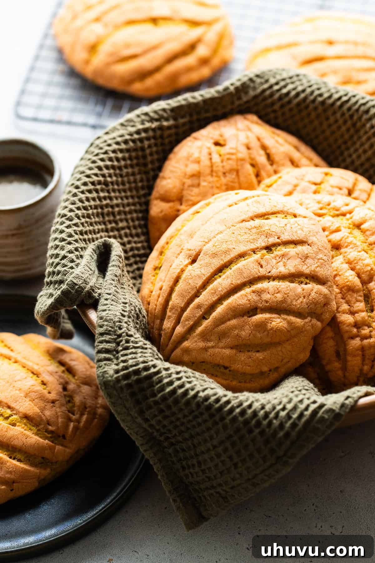 Spiced Pumpkin Conchas 6 A basket filled with warm, freshly baked pumpkin conchas, ready to be served.