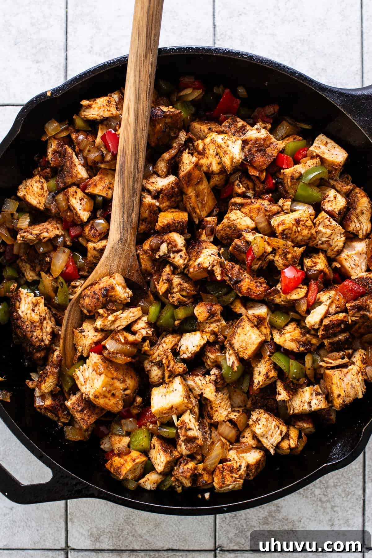 Zesty Chicken Fajita Quesadilla 5 Seasoned chicken pieces cooking in a skillet, browning beautifully alongside the aromatic vegetables.