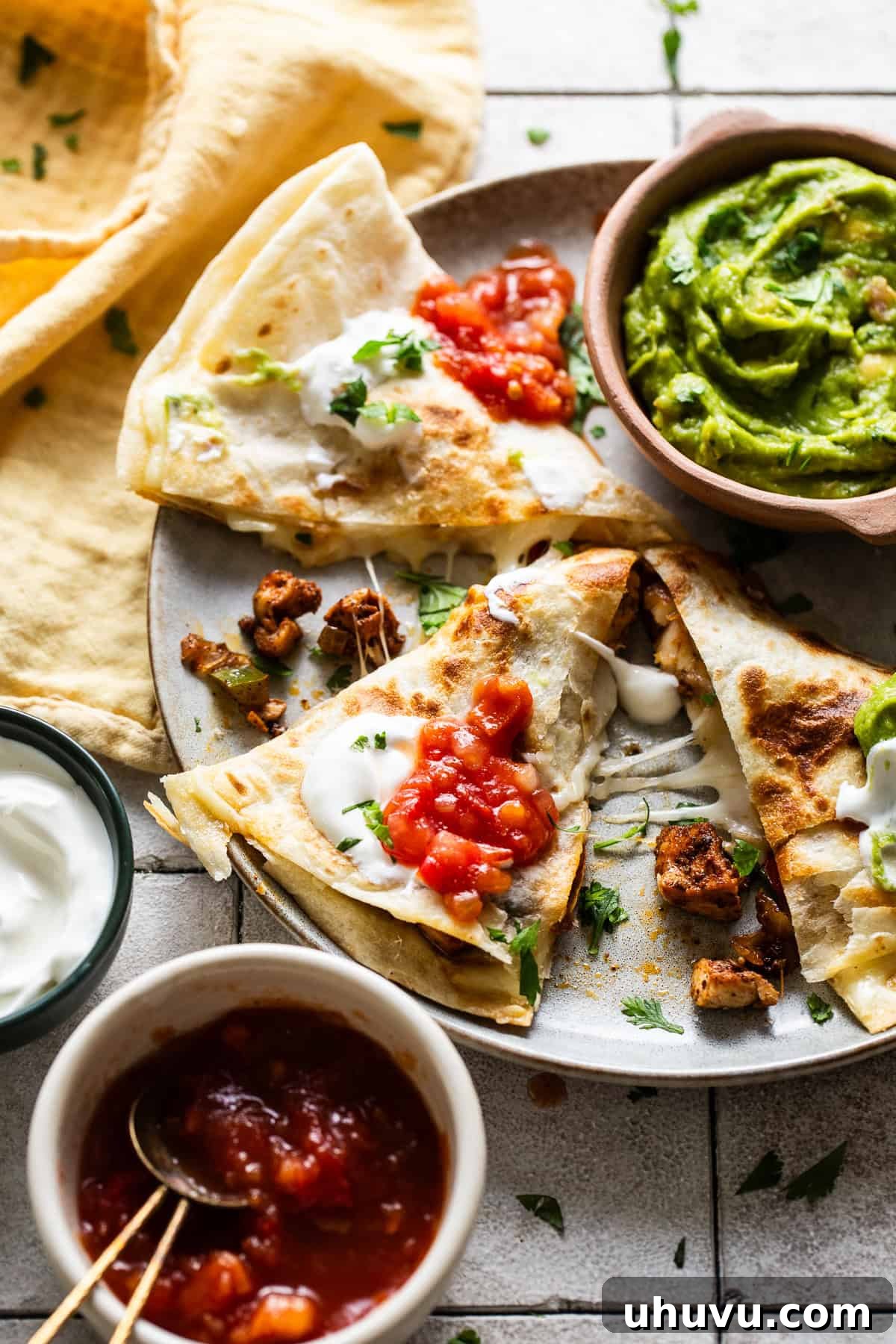 Zesty Chicken Fajita Quesadilla 8 Chicken fajita quesadillas cut into triangles and served on a plate with a side of creamy guacamole.