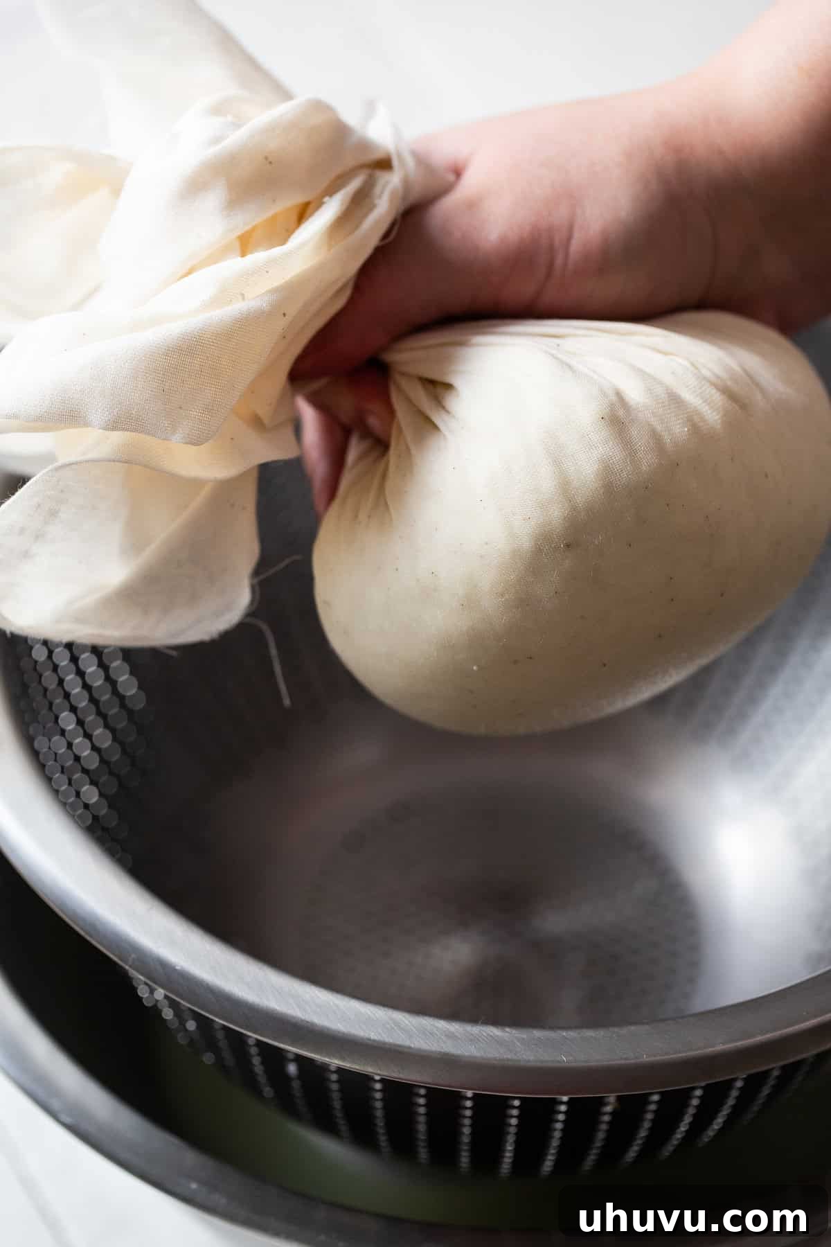 Make Your Own Queso Fresco 6 Queso fresco curds being pressed into a compact hockey puck shape inside the cheesecloth for further draining and shaping.