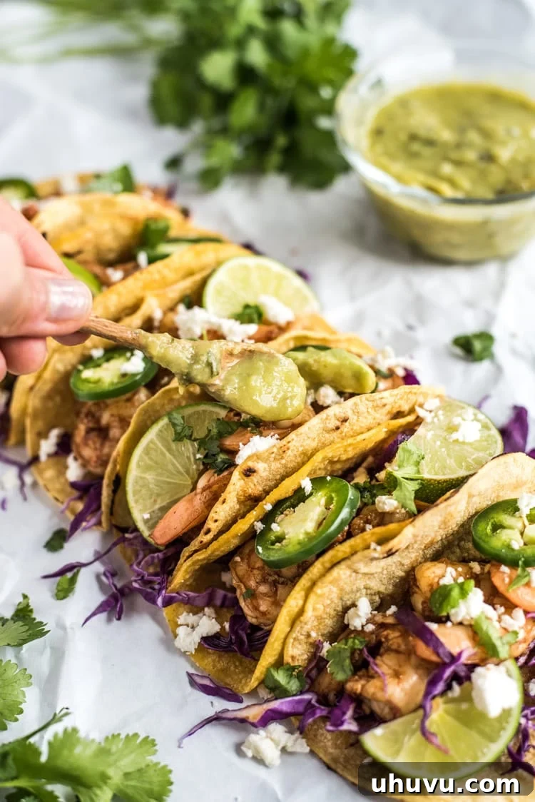 Plated Honey Balsamic Beer Shrimp Tacos with fresh cilantro, red cabbage, and lime wedges.