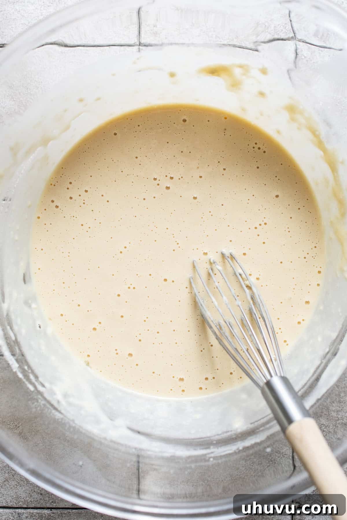 Wind Fritters 5 The batter for buñuelos de viento being whisked together in a bowl, showing its smooth consistency.