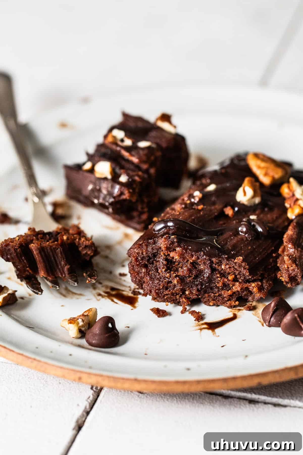 A chocolate tamale on a plate, delicately cut in half to reveal its fluffy, moist, and gooey chocolate chip-filled interior.