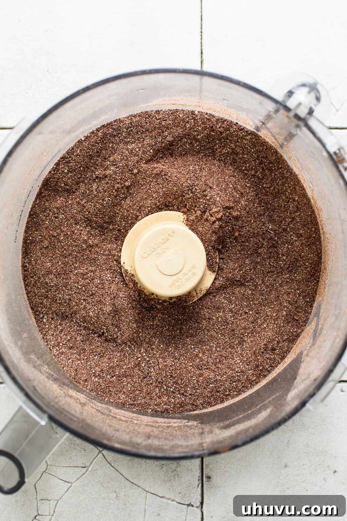 Ground Mexican chocolate in a food processor, transformed into a fine powder, ready for mixing into the masa dough.