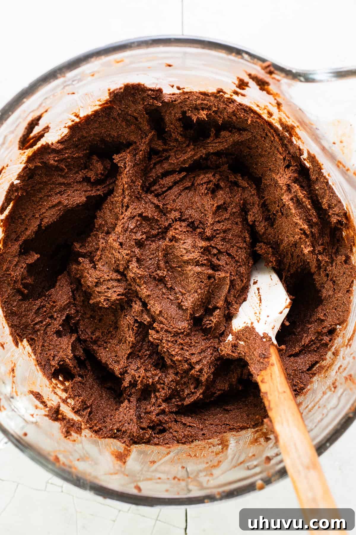 Rich chocolate masa dough, perfectly light and fluffy, in a stand mixer bowl, ready to be spread onto corn husks for chocolate tamales.