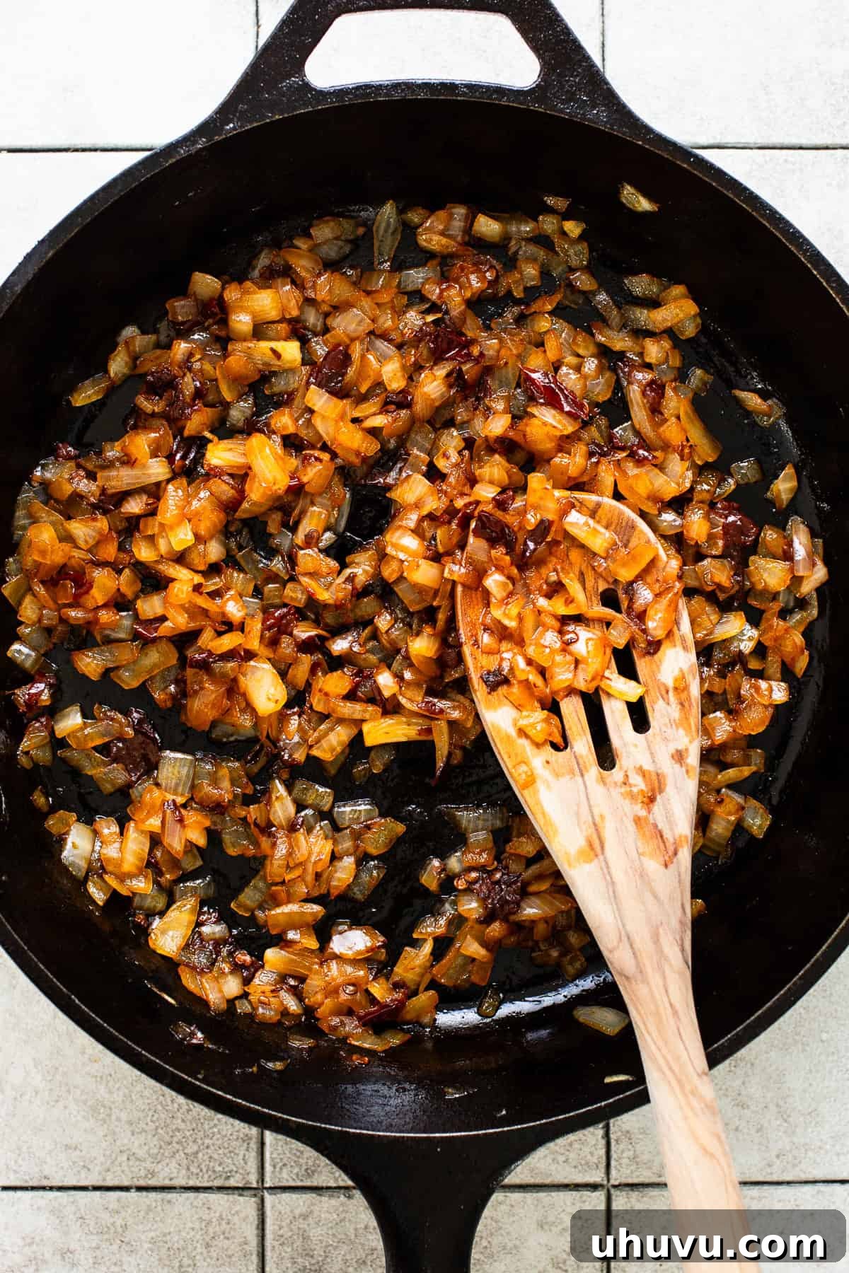 Crispy Black Bean Stacks 4 Diced white onions and chopped chipotle peppers in adobo sauce sautéing in a cast iron skillet, emitting a savory aroma.