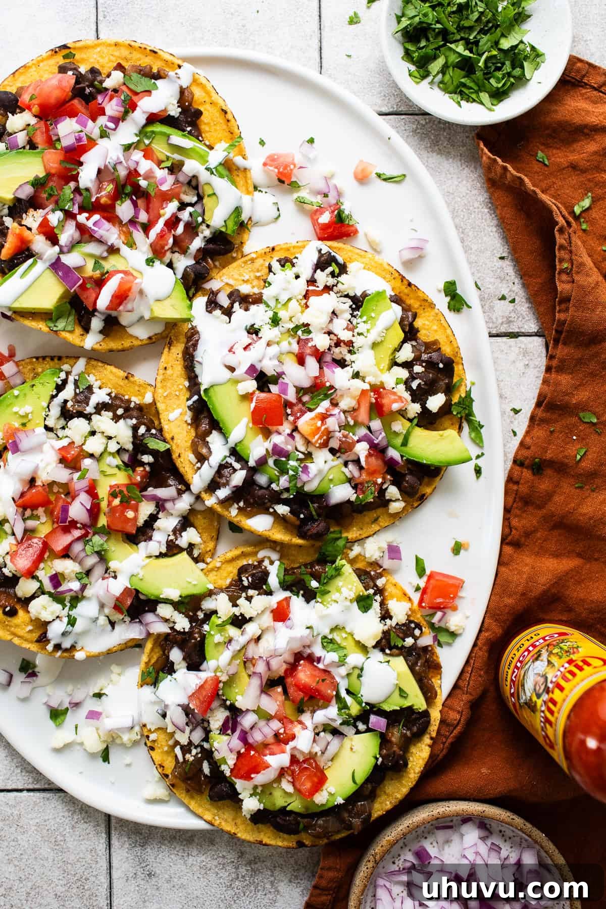 Crispy Black Bean Stacks 7 Beautifully assembled black bean tostadas with a generous amount of toppings, ready to be served and enjoyed.