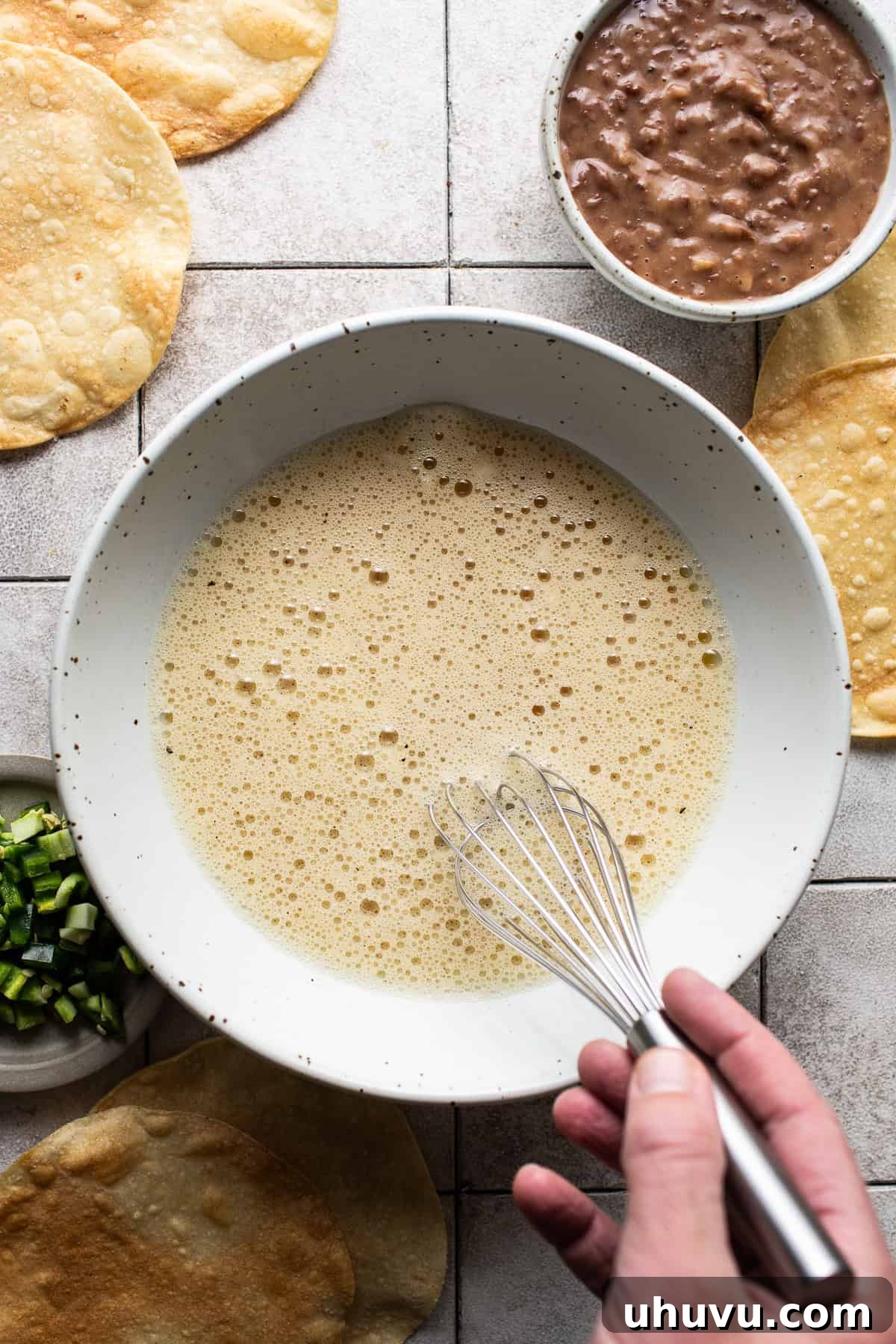 Sunrise Crunch Tostadas 4 A large mixing bowl with all the eggs and seasonings being mixed until well combined and fluffy.