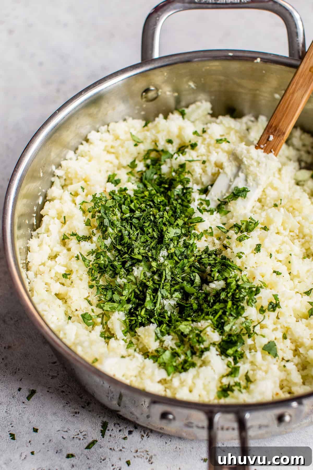 Zesty Cilantro-Lime Cauliflower Rice 6 Chopped cilantro and lime juice being added on top of cooked cauliflower rice before being mixed in.