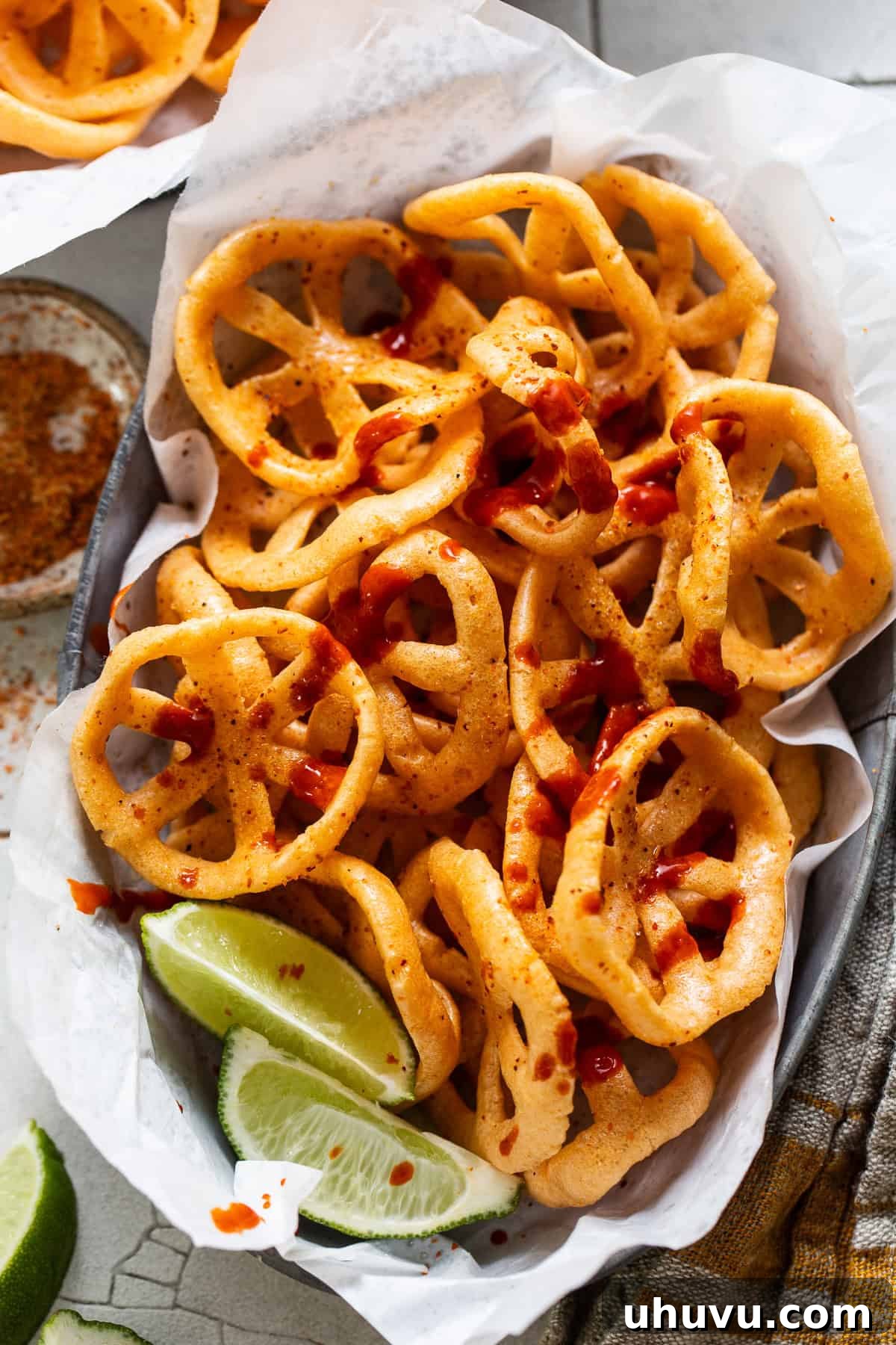 A serving of duros (chicharrones de harina) generously topped with hot sauce and fresh lime juice.