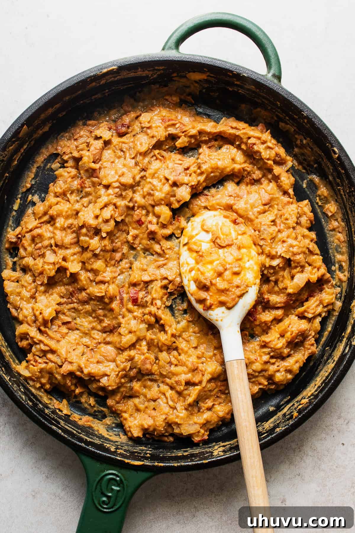 The mashed, smoky bean filling simmering in a skillet, ready for taquito assembly.