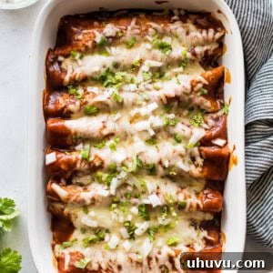 Turkey enchiladas in a baking dish topped with cilantro and onions.