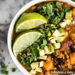 Turkey Pumpkin Chili in a white bowl with limes