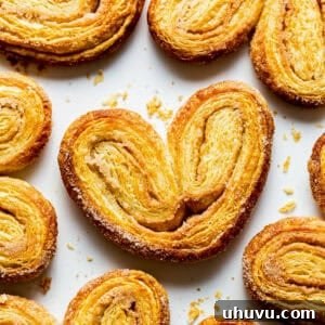 Crispy orejas pan dulce on a baking sheet with lots of cinnamon sugar.