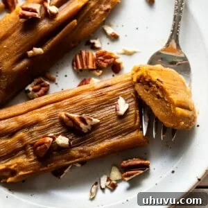 Pumpkin tamales on a plate garnished with some chopped pecans.
