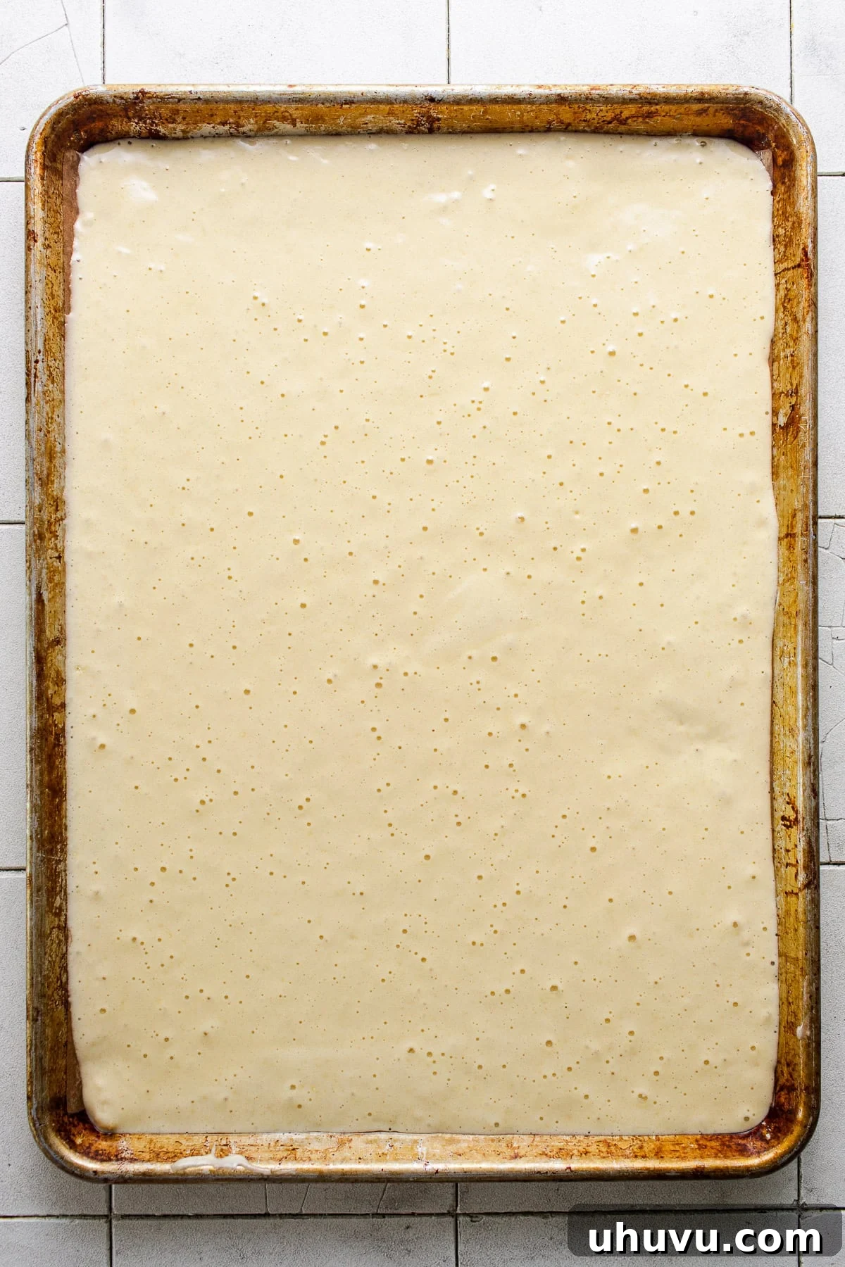 Wrapped Meat Bundles 5 The delicate, light yellow cake batter poured evenly into a parchment-lined sheet pan, ready for baking.