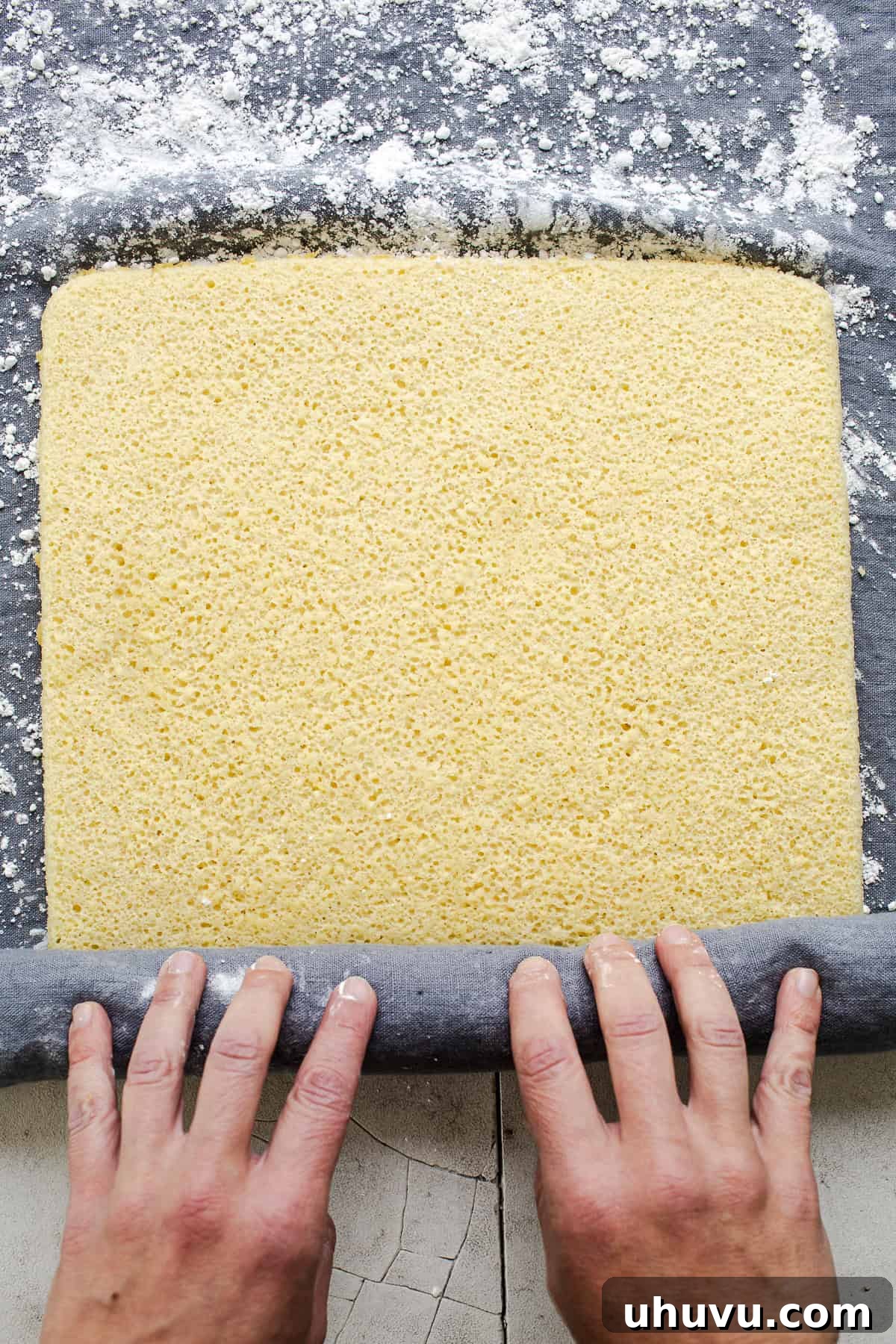 Wrapped Meat Bundles 6 The warm, freshly baked sponge cake being carefully rolled onto a towel dusted with powdered sugar, a critical step for preventing cracks.
