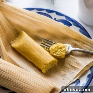 A delectable cooked Sweet Corn Tamale (Tamal de Elote) served on a plate, perfectly paired with a steaming cup of coffee.