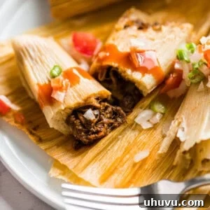 An Instant Pot Pork Tamale, perfectly cooked and cut in half to showcase its tender, flavorful pork filling.