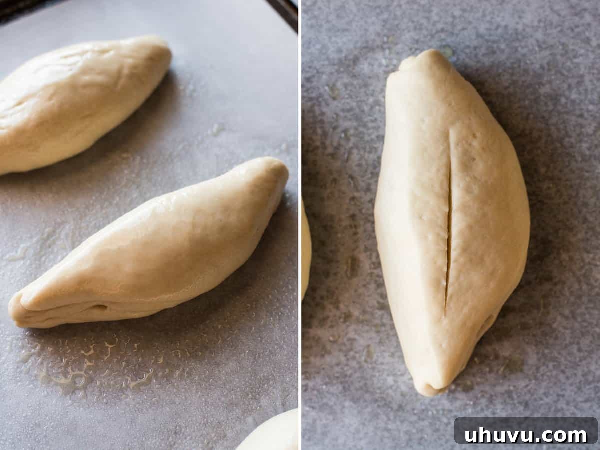 Mexican Bolillo Rolls 10 Shaped bolillo bread dough rising on a baking sheet and then a thin slit cut into the middle.