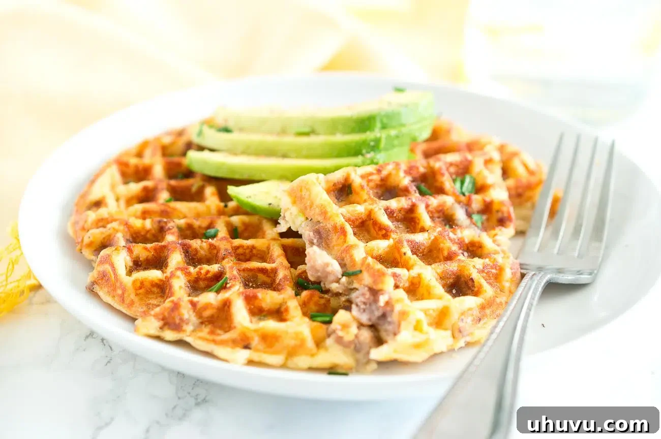 Sausage and Potato Waffles served on a plate with fresh greens and a fork