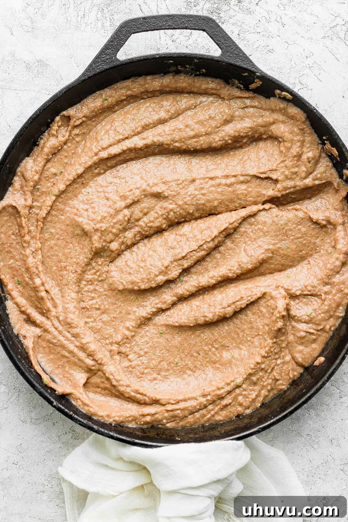 Velvety Frijoles 11 Smooth and creamy refried beans in a skillet ready to be served.