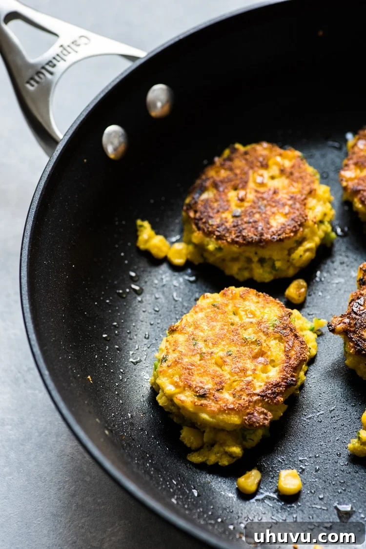 A plate of freshly pan-fried Jalapeno Corn Cakes ready to be served, highlighting their golden color and inviting aroma.
