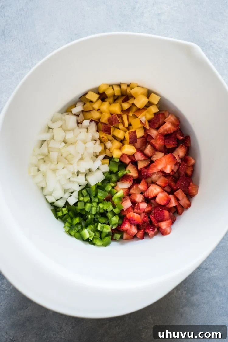 An overhead shot of the fresh Peach Strawberry Salsa in a rustic bowl, ideal for a bright summer appetizer.