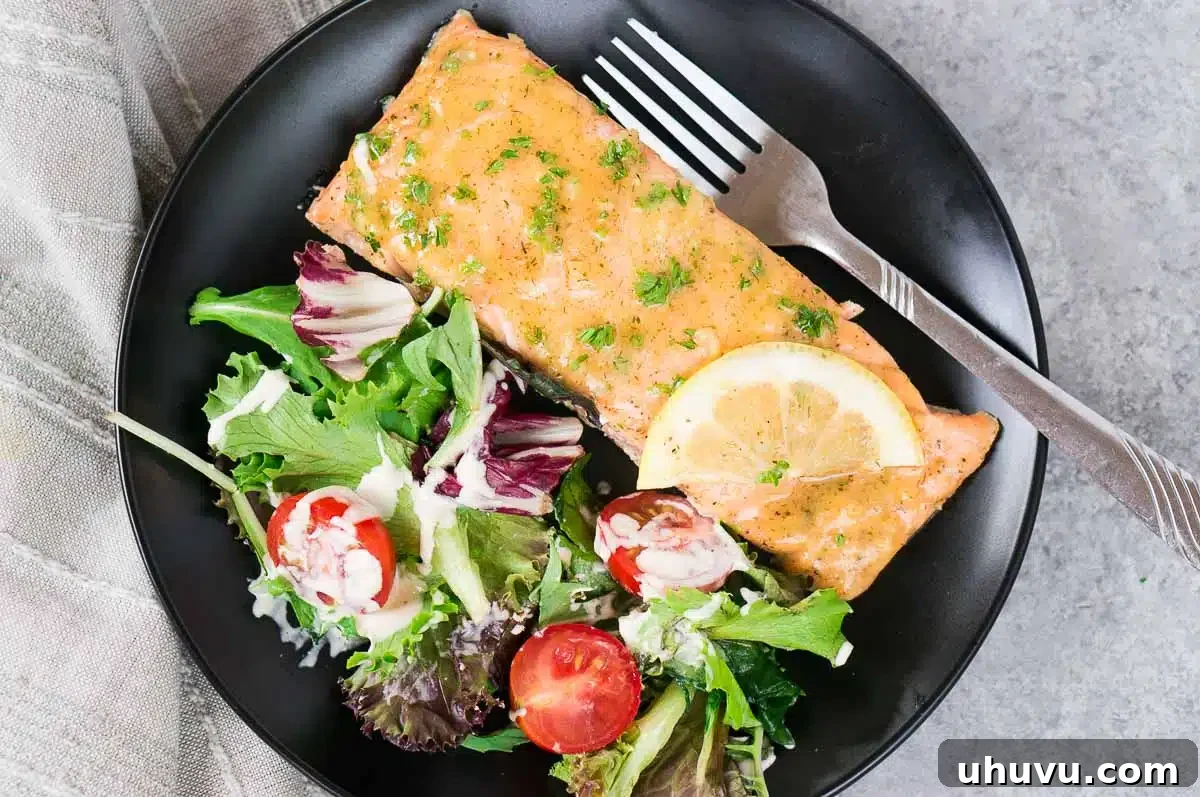 baked salmon on a plate with a green salad