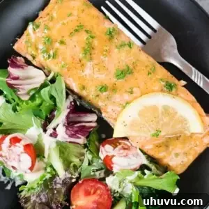 maple mustard salmon on a black plate with green salad