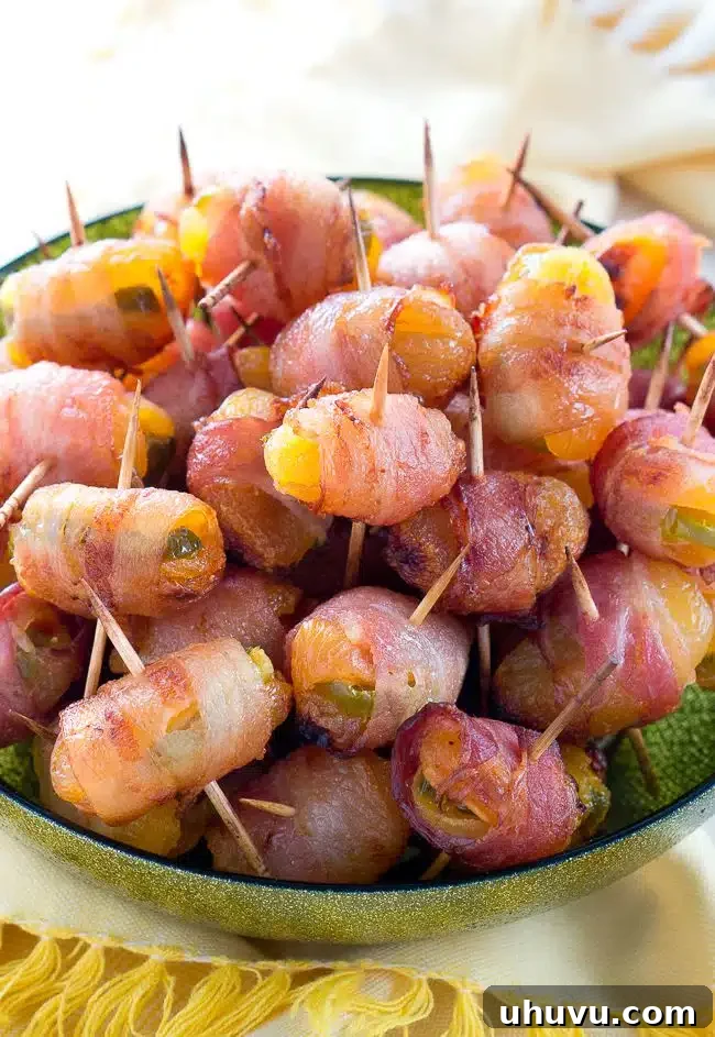 Fiery Apricot-Bacon Bundles 4 A tray of bacon-wrapped apricots with jalapeño, showcasing their golden-brown crispiness and vibrant colors.