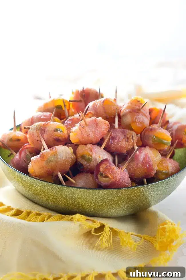 Fiery Apricot-Bacon Bundles 6 A close-up shot of raw bacon-wrapped apricots with jalapeño secured with toothpicks on a baking rack, ready for the oven.