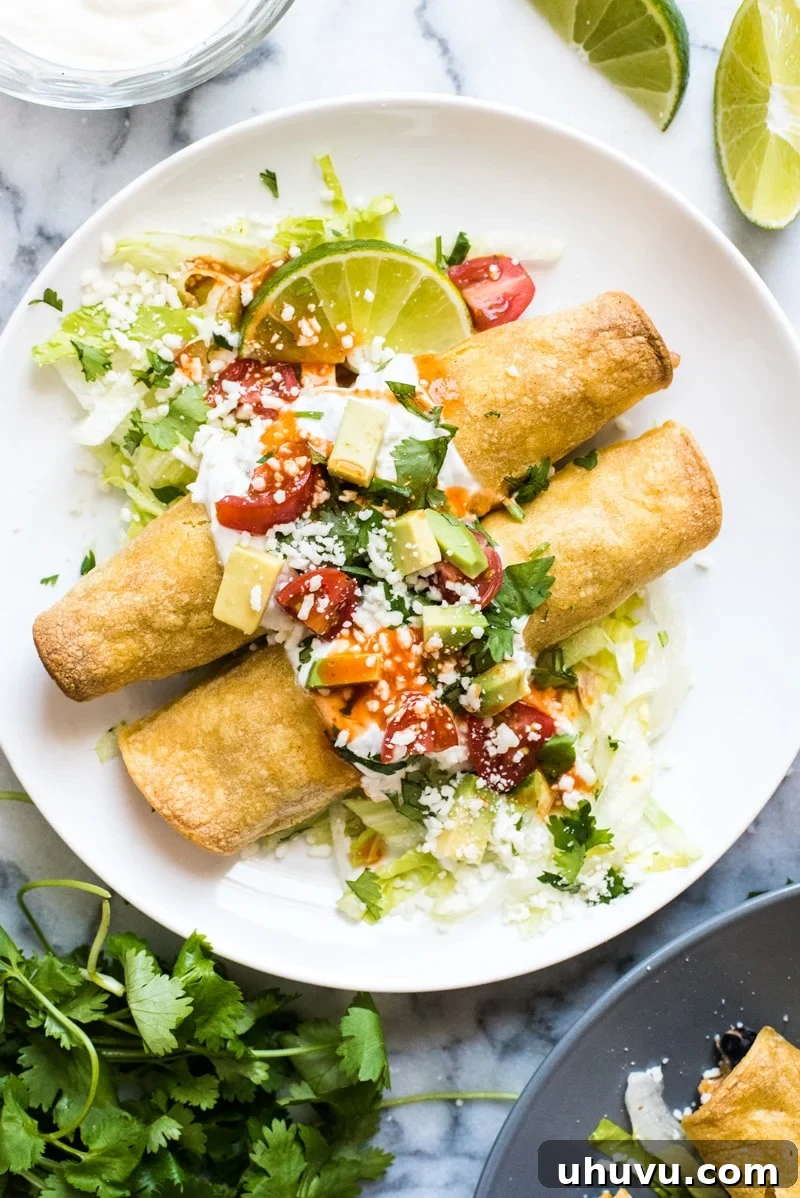 Crispy baked chicken taquitos filled with seasoned shredded chicken, cream cheese, black beans, corn, and green chiles